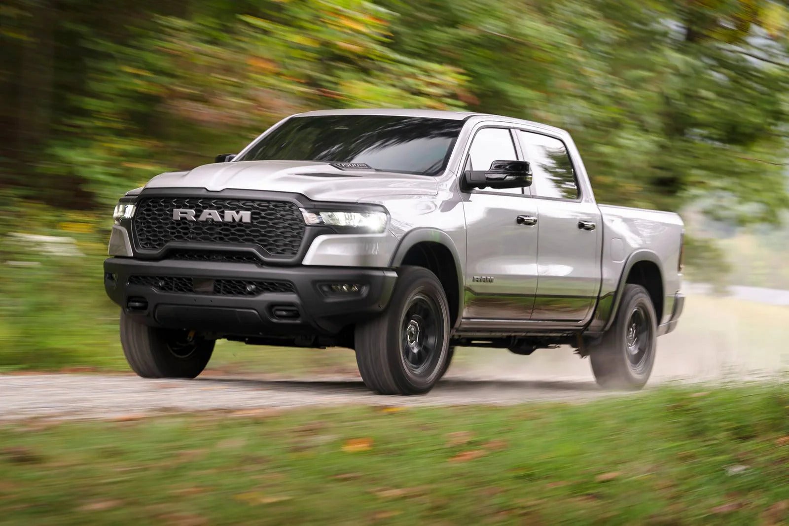 A gray ram truck driving on the road.