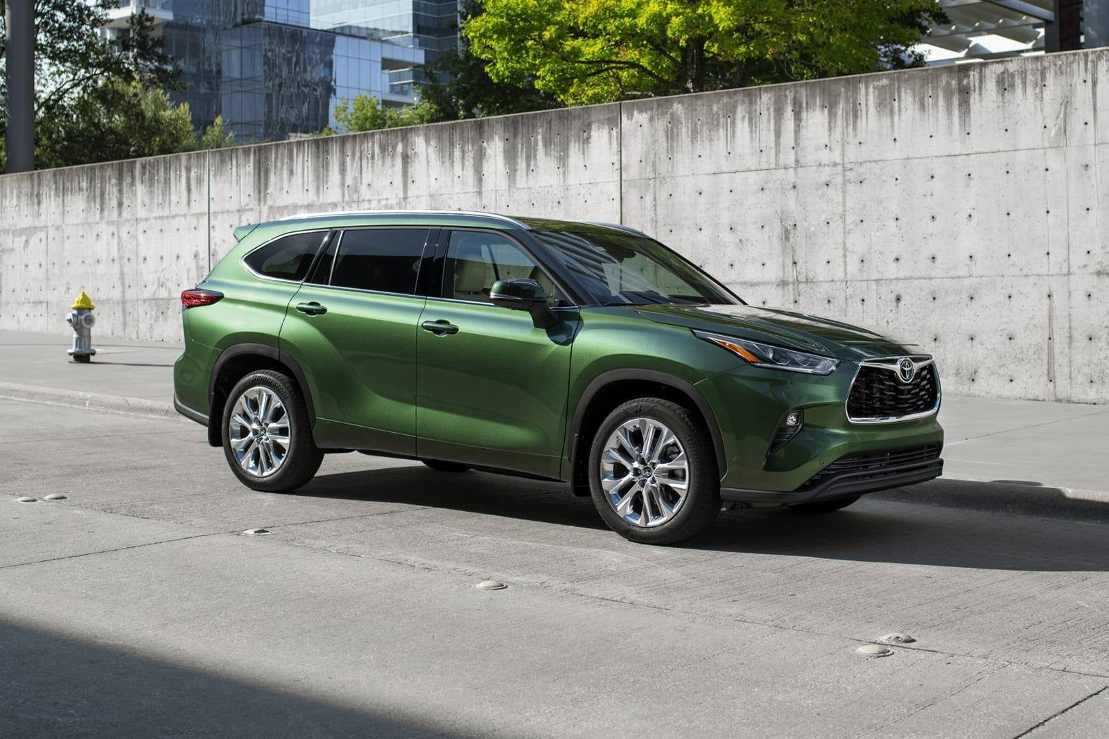 A green suv sitting in the road.