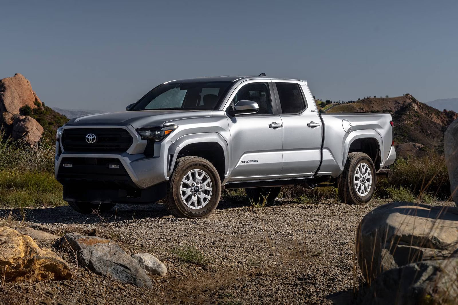 A silver truck sitting parked off-road.