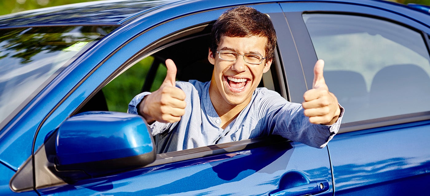 college student in vehicle with thumbs up