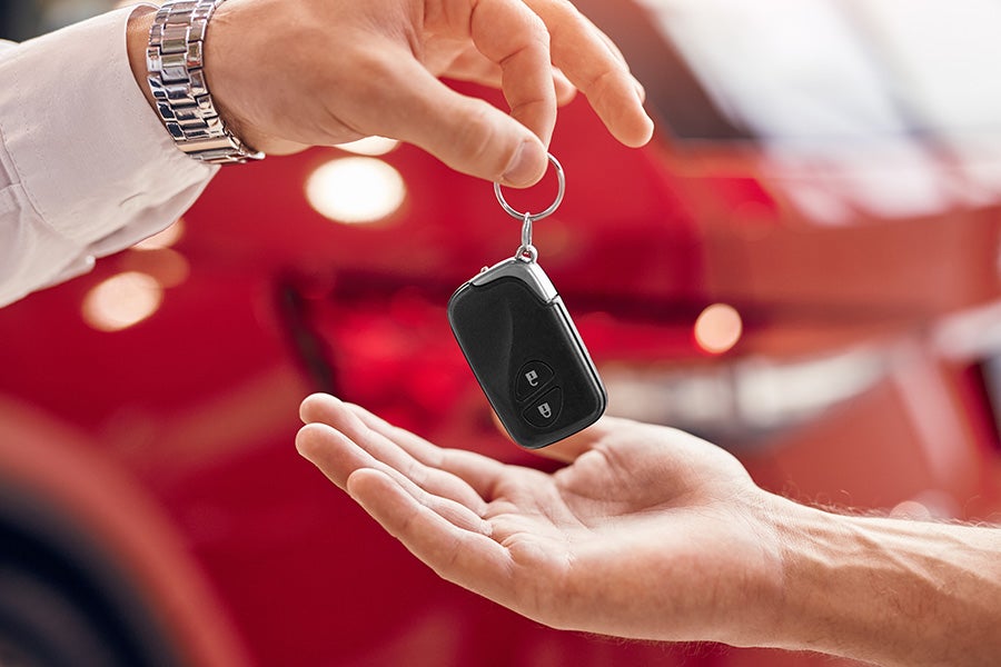 a person handing car keys to another person
